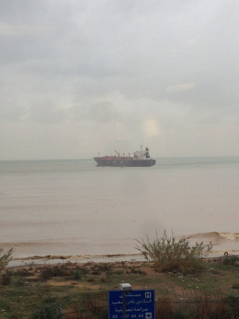 sea, water, sky, horizon over water, transportation, nautical vessel, mode of transport, tranquility, text, cloud - sky, tranquil scene, beach, scenics, nature, western script, shore, beauty in nature, boat, guidance, cloudy