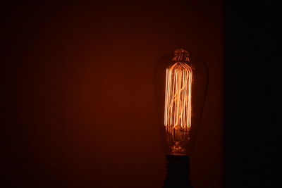 Close-up of illuminated light bulb in darkroom