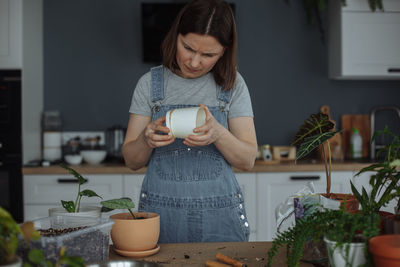 Gardener holding plants at home