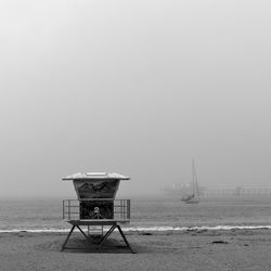 Lifeguard hut on beach against sky