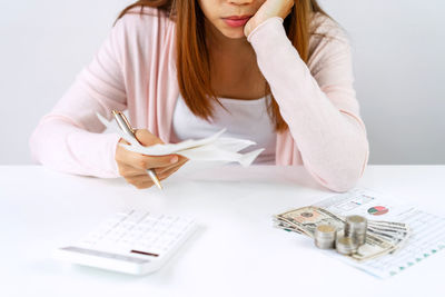 Midsection of a woman sitting on table