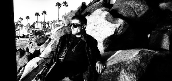 Portrait of young man wearing sunglasses sitting outdoors