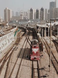 Train on railroad tracks in city against sky