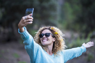 Smiling woman taking selfie while standing outdoors