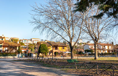 Houses by street in city against clear sky