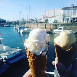 Close-up of hand holding ice cream at harbor