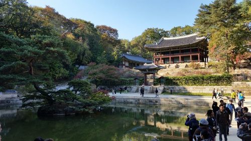 People by artificial pond in garden