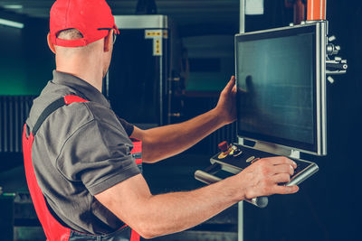 Rear view of man using digital tablet