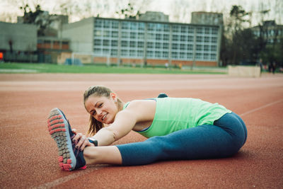 Portrait of young woman exercising on sports track