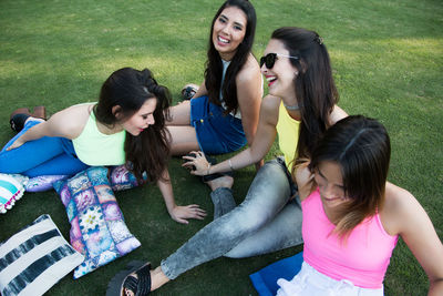 Young women smiling while sitting on grass