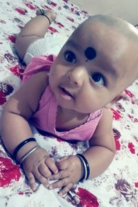 Close-up portrait of cute baby girl in bed
