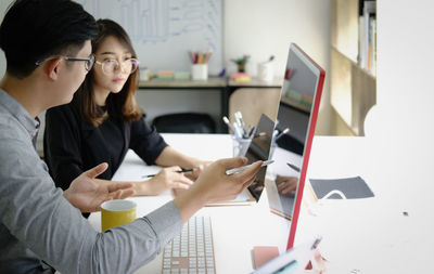 Woman using phone while sitting on table