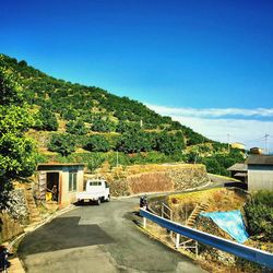 Road leading to mountain against blue sky