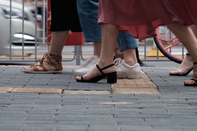 Low section of women walking on footpath