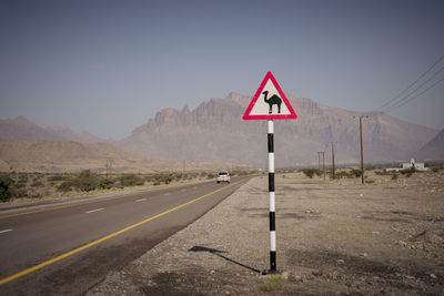 Road sign against sky