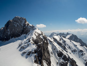 Scenic view of snowcapped mountains against blue sky