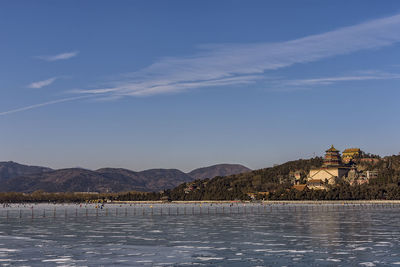 Scenic view of lake by buildings against sky