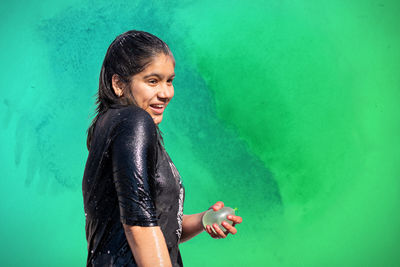 Side view of young woman standing against blue sky