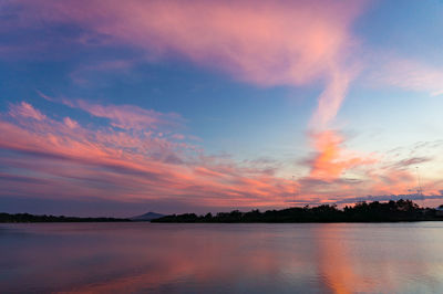 Breathtaking pink and blue sunset sky over river with colorful clouds reflected in water