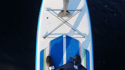 Low angle view of people in boat against blue sky