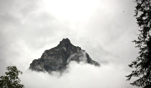 Low angle view of mountain against cloudy sky