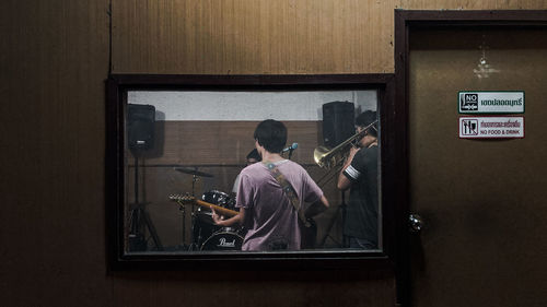 Rear view of man playing guitar