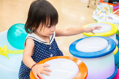 High angle view of baby girl playing music