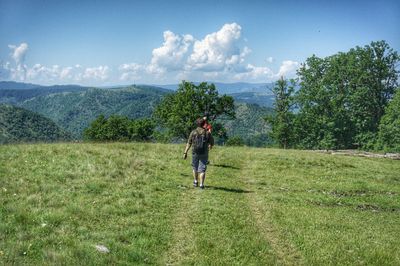 Rear view of man on field against sky, zlatibor mountain