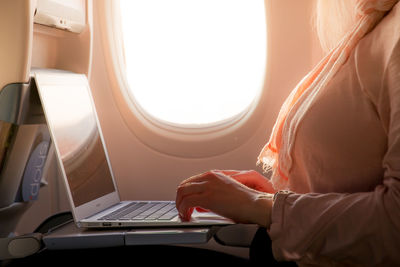 Midsection of woman working in airplane