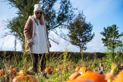 Portrait of young woman standing in a pumpkin patch 