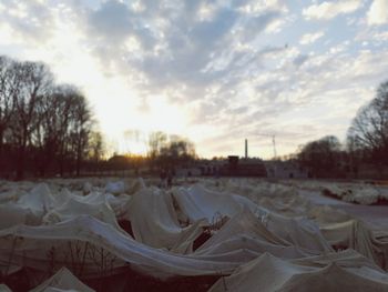 Snow covered land against sky during sunset