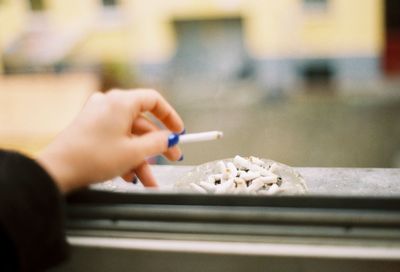 Close-up of woman hand holding cigarette