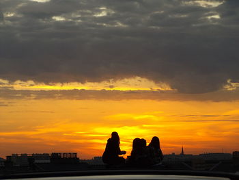 Silhouette of city against dramatic sky