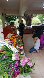 Group of people sitting on table against plants