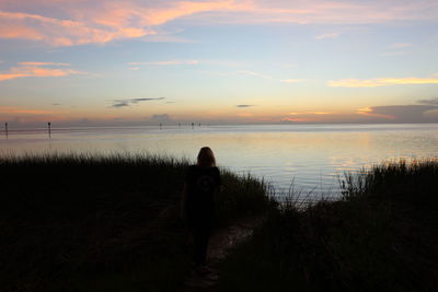 Rear view of woman standing on beach