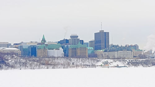 Buildings in city against sky during winter