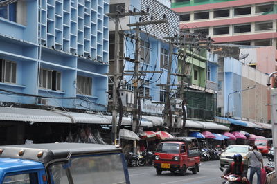 Traffic on road by buildings in city