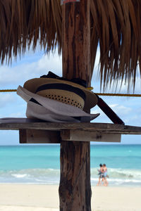 Hats on shelf of parasol on shore