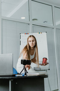 Young woman blogging over smart phone at home