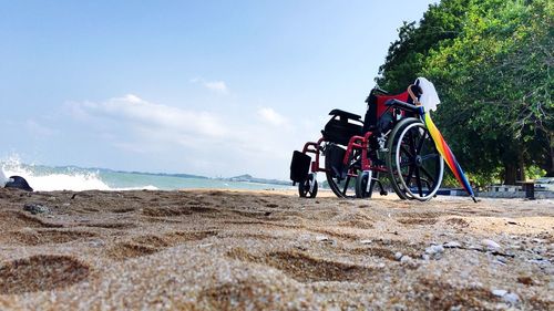 Bicycle on beach against sky