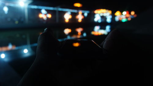 Midsection of person holding illuminated lights at night