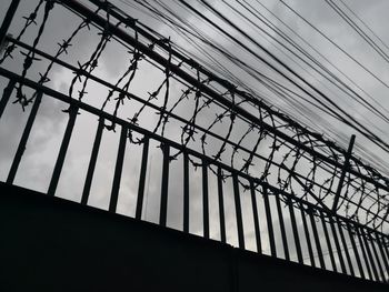 Low angle view of silhouette bridge against sky