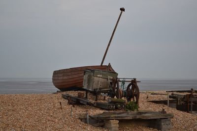 Abandoned boat at beach against clear sky