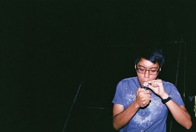 Young man smoking marijuana joints at night