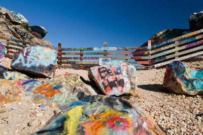 Graffiti on mountain against clear blue sky