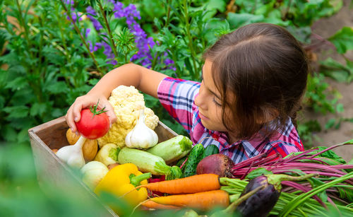 Smiling girl holding vegetables in basket