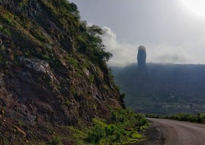 Road by mountain against sky