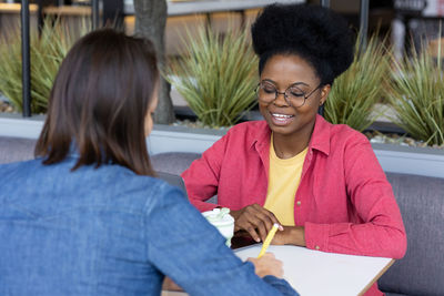 African american female student or freelancer in a public place talking to a colleague