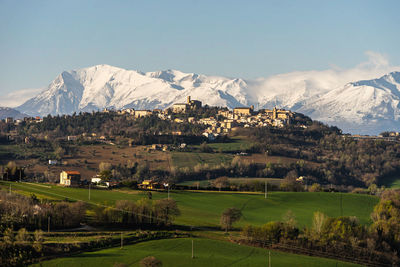 Scenic view of field and snowcapped mountains against sky