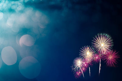Low angle view of firework display at night